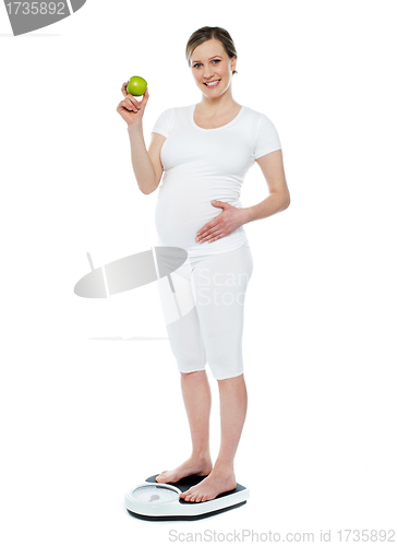 Image of Pregnant woman standing on weighing machine