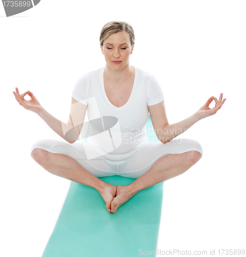 Image of Young woman meditating in lotus pose