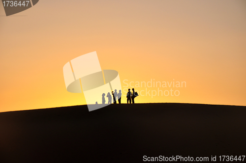 Image of Silhouette of travelers at sunset