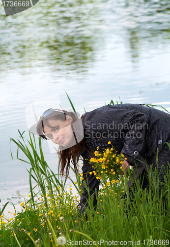 Image of pretty girl collects a flowers