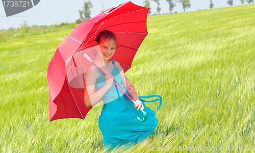 Image of teenage girl with red umbrella in wheat field 
