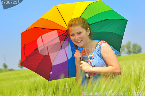 Image of teenage girl with umbrella in wheat field