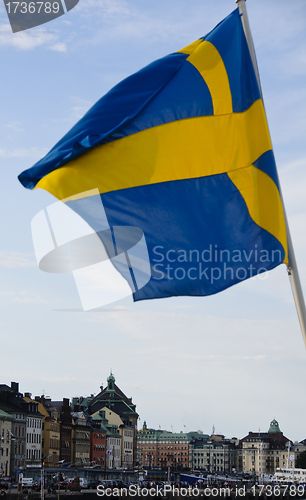 Image of Swedish flag waving over the buildings of Stockholm old town