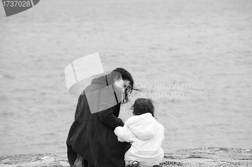 Image of Back view of mother and daughter in beautiful spring sea