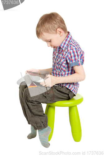 Image of boy with a Tablet PC sitting on a green children's chair