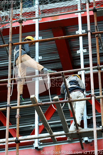 Image of Two builders on a steel scaffold