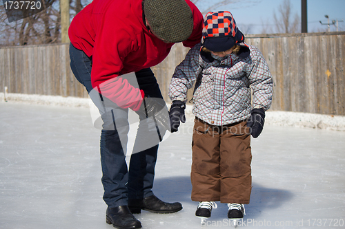 Image of Father teaching son how to ice skate