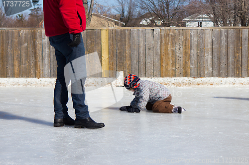 Image of Father teaching son how to ice skate