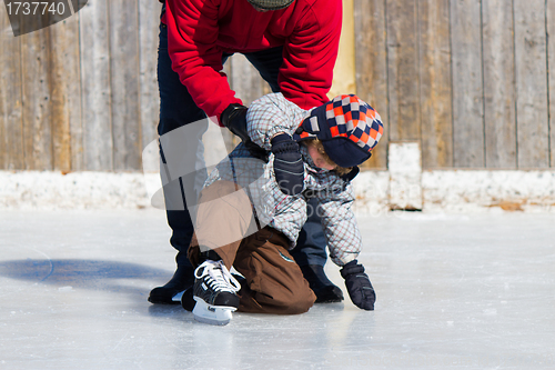 Image of Father teaching son how to ice skate