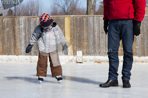 Image of Father teaching son how to ice skate