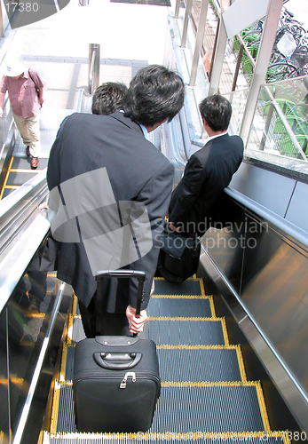 Image of Businessmen on moving staircase