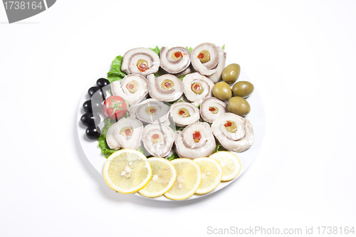 Image of fish slices served with tomato and olives, and lemon