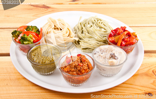 Image of two italian tagliatelles and five various condiments