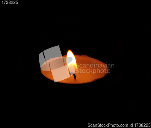 Image of A single burning yellow candle