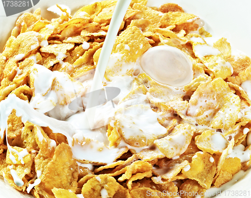 Image of milk stream flowing to the bowl with corn flakes