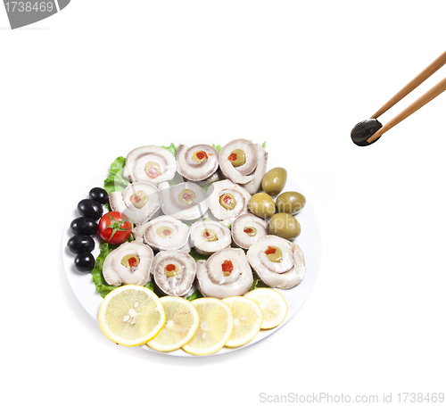 Image of fish slices served with tomato and olives, and lemon