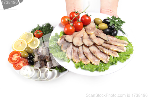 Image of human hand with plate and slices fish