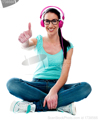 Image of Thumbs-up woman enjoying music