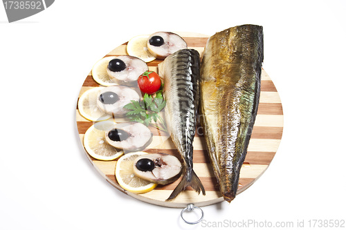 Image of Dish with the cut smoked mackerel on wooden plate