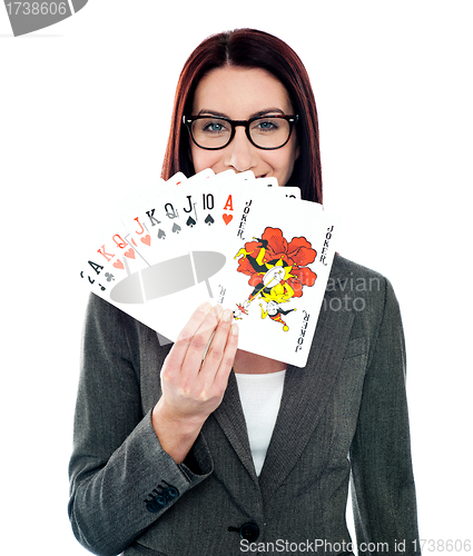 Image of Corporate lady hiding her smile with playing cards