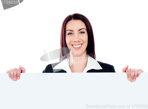 Image of Young beautiful woman standing behind billboard