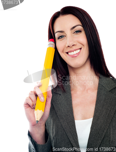 Image of Thoughtful businesswoman holding big pencil