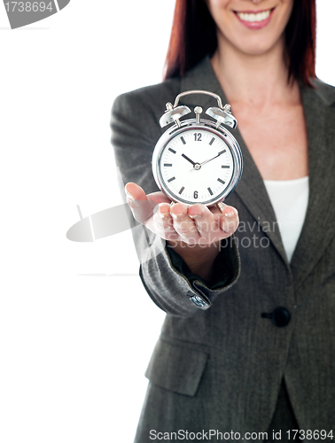 Image of Cropped image of a woman holding alarm clock