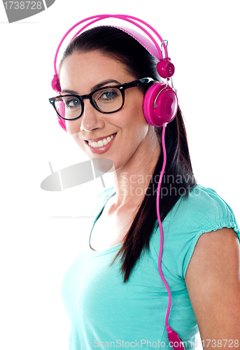 Image of Pretty girl tuned into listening music via headphones