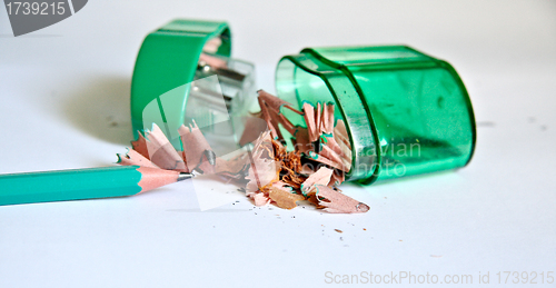 Image of Sharpened pencil next to the sharpener and shavings.