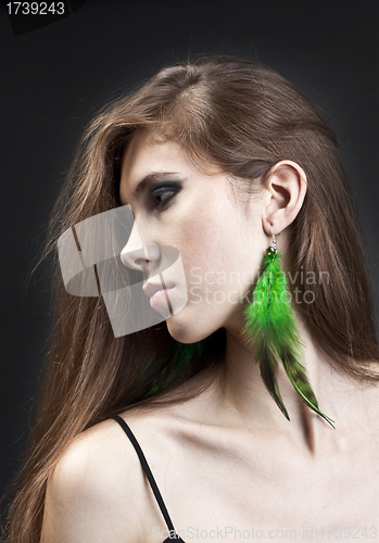 Image of Young pretty girl with green earrings