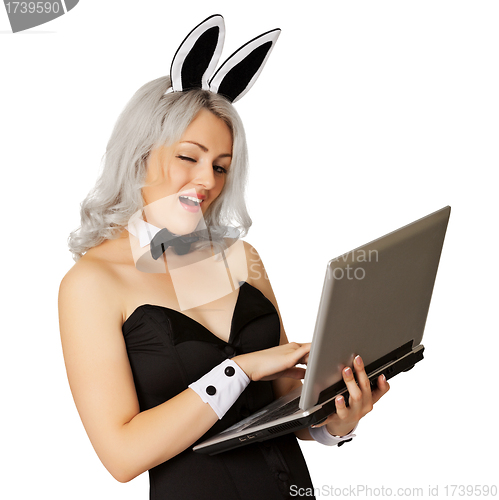 Image of Playful girl dressed as a rabbit with a laptop
