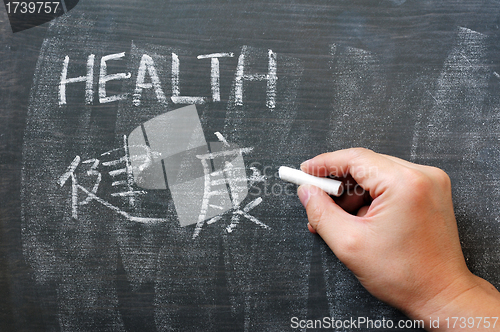 Image of Health - word written on a blackboard with a Chinese version