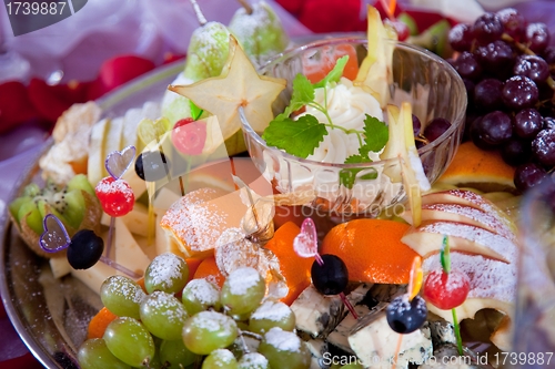 Image of festive dish with fruit, cheese and sauce