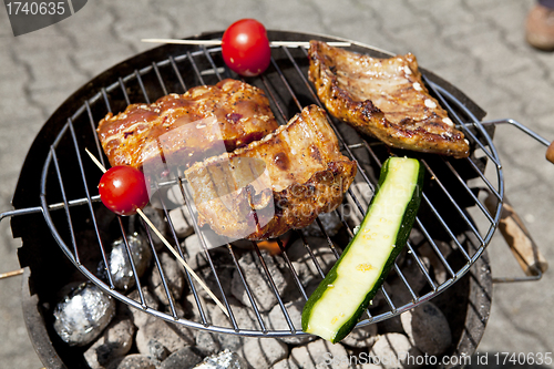 Image of barbecue grill wiht meat outside in summer