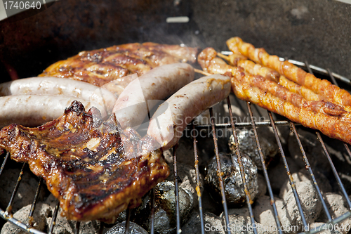 Image of barbecue grill wiht meat outside in summer