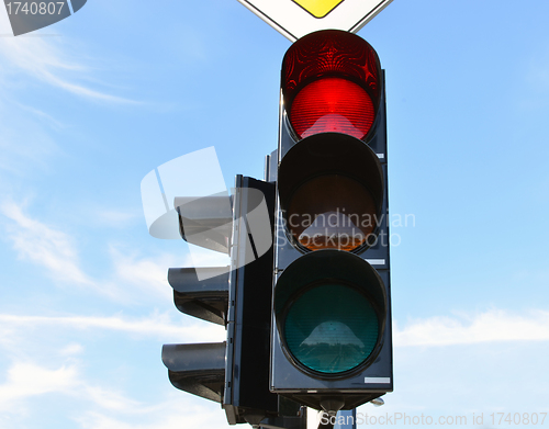Image of Red color traffic light blue sky in background 