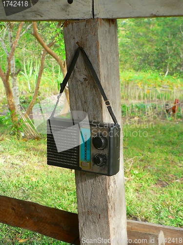 Image of Old transistor radio hanging on wooden post