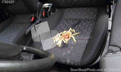 Image of Messy French fries spilt on car seat