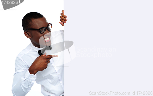 Image of African young man pointing at blank billboard