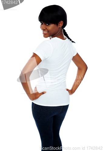 Image of Rear view of a girl keeping hands on her waist