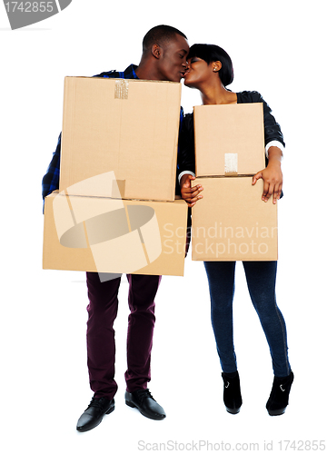 Image of Couple holding cardboard boxes and kissing