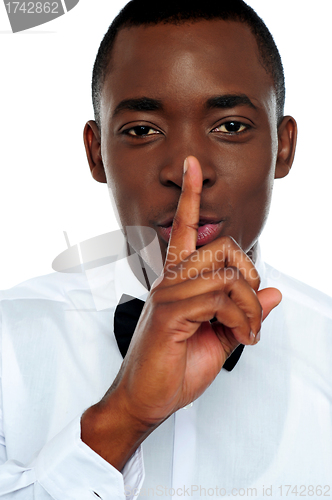 Image of Black man showing silence gesture