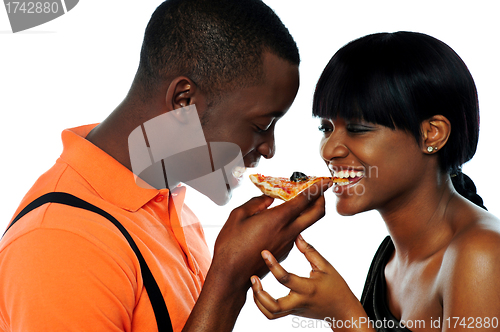 Image of Young couple sharing a slice of pizza