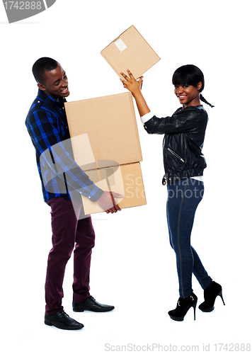 Image of Smiling couple moving cardboard boxes