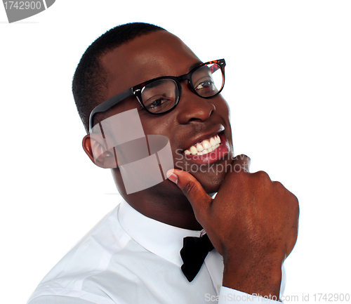 Image of Smiling young man with hand on chin