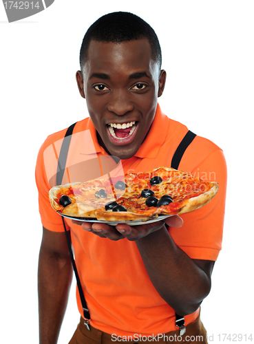 Image of Boy in uniform offering pizza