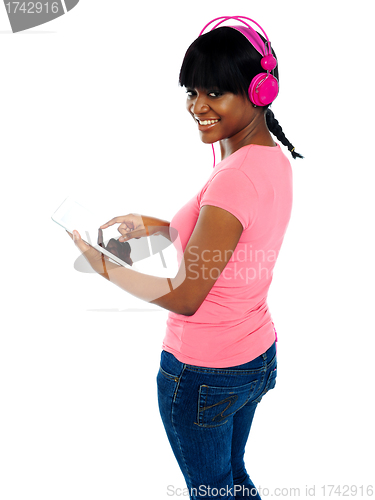 Image of Girl listening to music via portable tablet