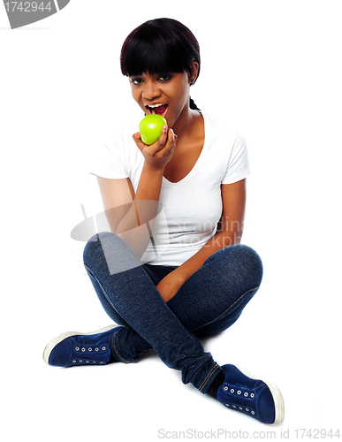 Image of Young girl eating fresh green apple