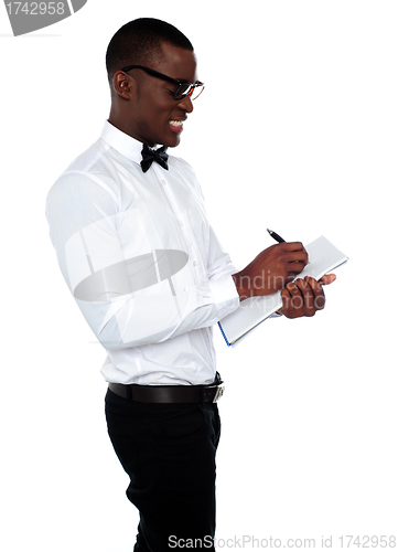 Image of African employee writing on clipboard