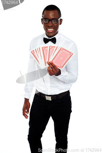 Image of A man holding up a few playing cards